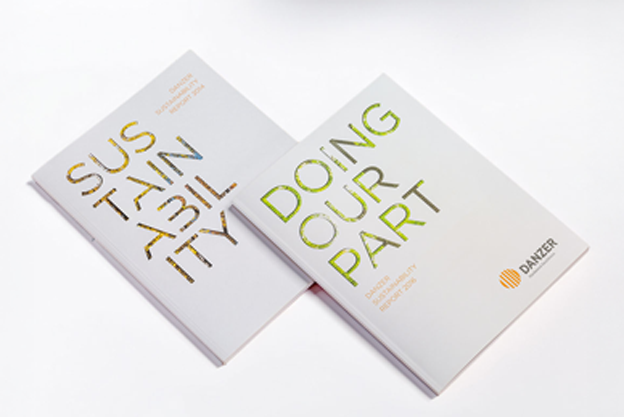A top-down view of printed Danzer Sustainability Reports titled "Sustainability" and "Doing Our Part".